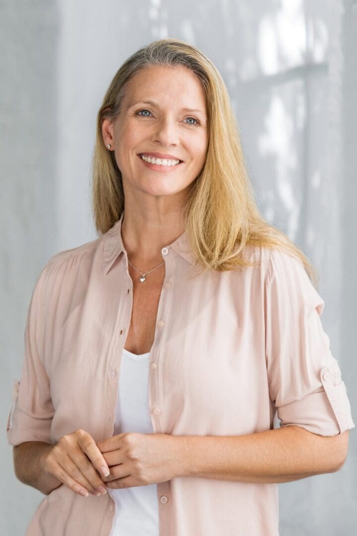 Smiling woman in light pink blouse