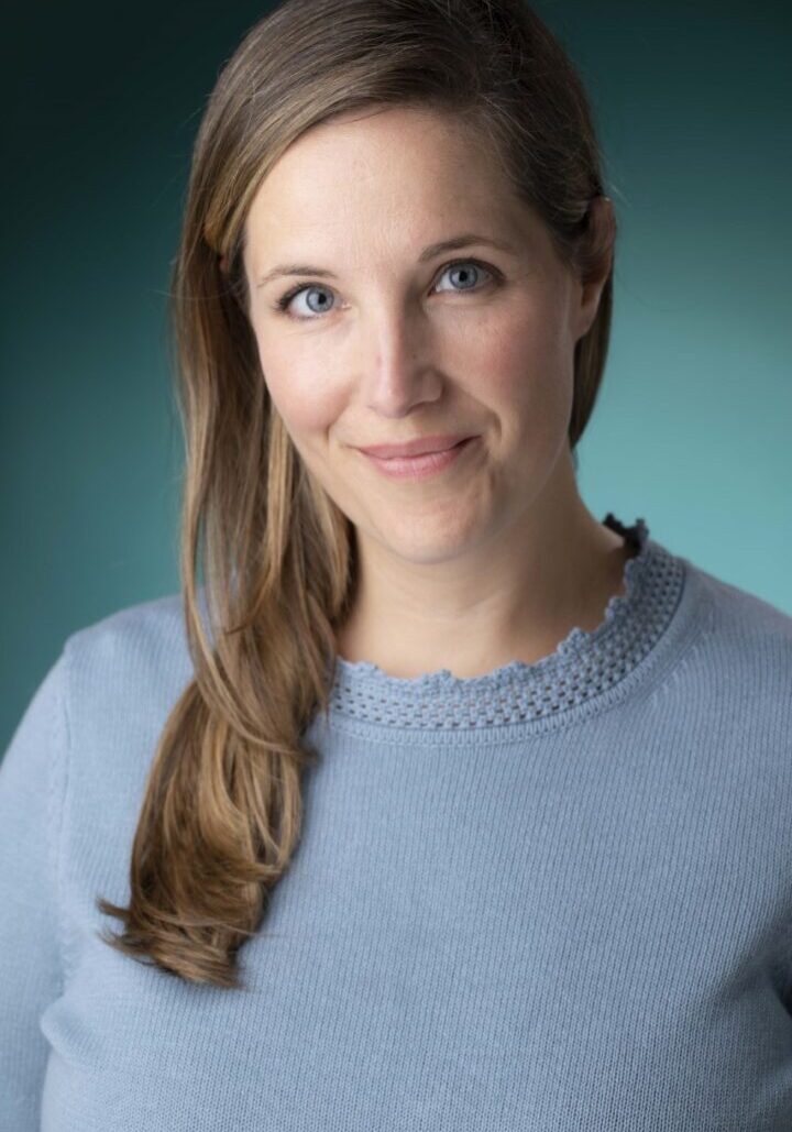Smiling woman in blue sweater portrait.
